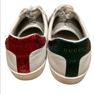 Off white colored low top sneakers by Gucci